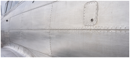 Detail of a metal panel showing scratches and rivets.